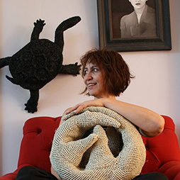 Mikaela Castledine in red chair with pangolin. Image courtesy of the artist 